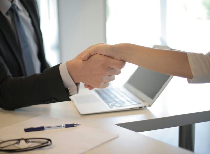 Board Room Hand Shake Handshake as part of merger and acquisition.